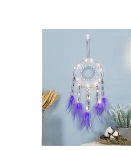 Detail of purple dream catcher with glowing LED lights and soft hanging feathers