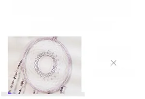 Macro shot of purple dreamcatcher detailing woven mesh with pearls and amethyst stones