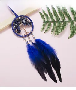 Détail d'un attrape-rêves arbre de vie avec cristaux bleus et plumes en dégradé