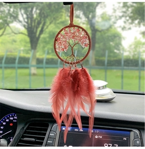 Dettaglio del ciondolo auto albero della vita con cristalli rosa e piume rosso-brune