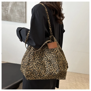 Macro detail of leopard print tote bag texture and brown leather patch on the front
