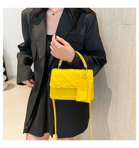 Detailed macro view of yellow quilted leather bag with woven handle and fashion emboss
