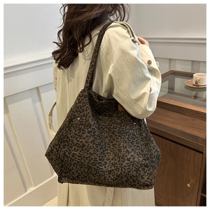 Détail du grand sac cabas en toile léopard avec rivets métalliques et poche texturée