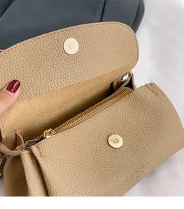 Detail of light khaki leather crossbody bag with golden magnetic snap closure and zipper