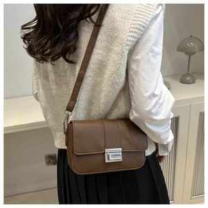 Borsa a tracolla marrone in ecopelle con chiusura argento indossata dalla modella