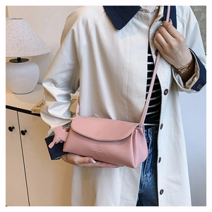 Detail of pink pebbled leather crossbody bag with cute elephant charm and logo
