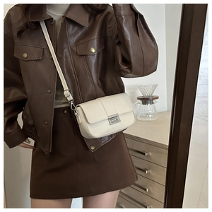 Dettaglio della borsa a tracolla beige minimalista con chiusura in metallo argento