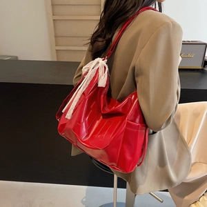 Fashionable red glossy tote bag with white lace bow for casual commuting style