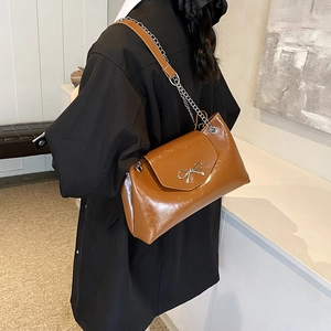 Sac à épaule en cuir verni marron brillant avec nœud argenté et bandoulière chaîne