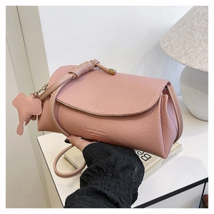 Pink lychee grain leather crossbody bag with elephant charm and decorative embossing