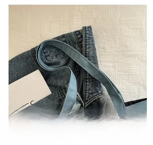 Close-up of durable light blue denim tote bag straps with reinforced stitching detail