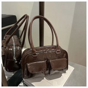 Detail of dark brown high-gloss handbag featuring double front square flap pockets