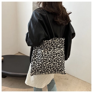 Detail of leopard print tote bag showing fabric texture and gold metal ring strap connectors