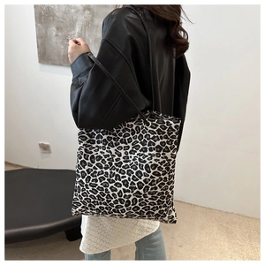 Detailed close-up of a large capacity leopard print tote bag worn on shoulder by a model