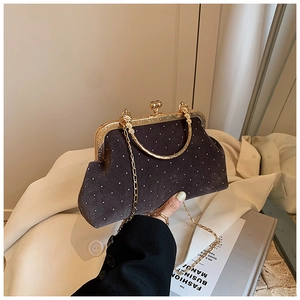 Detailed view of vintage velvet shell bag with sparkling rhinestones and gold metal clasp