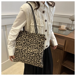 Chic leopard print canvas tote bag carried by a model in a minimalist indoor setting