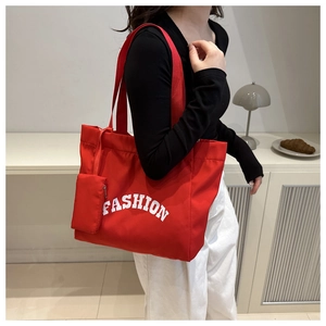 Détail du grand cabas en nylon rouge avec texte Fashion et petit porte-monnaie zippé assorti