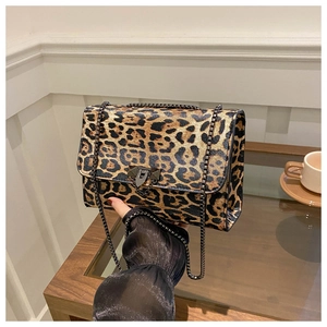 Close-up of leopard print handbag featuring a vintage metal clasp and long chain strap