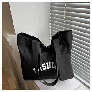 Détail du cabas en nylon noir avec imprimé FASHION blanc et petite pochette zippée
