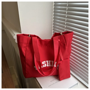 Détail du grand sac cabas rouge avec pochette assortie et lettrage blanc tendance