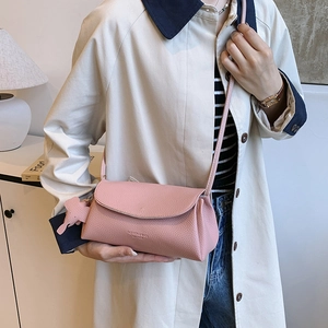 Pink lychee texture crossbody bag with elephant charm worn by a model in soft lighting