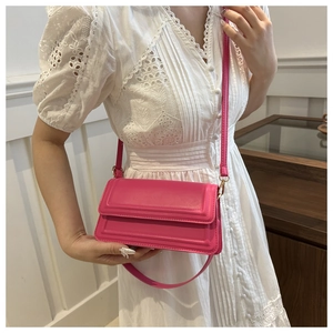 Vue détaillée du sac bandoulière rose fuchsia avec gaufrage géométrique et chaîne