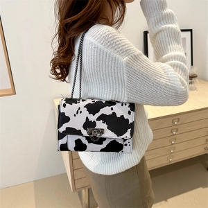 Fashionable cow print small square shoulder bag with metal chain strap on model