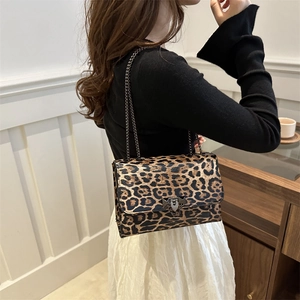 Stylish leopard print crossbody bag with metal chain strap and flap closure shown on model