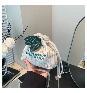 Close-up of summer woven bucket bag with green leaf patch and Summer embroidery