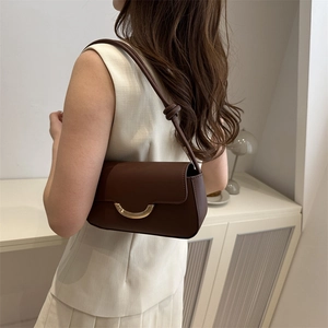 Brown leather baguette bag with gold half-moon buckle and knotted shoulder strap detail