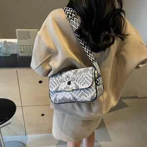 Sac bandoulière femme avec imprimé ondulé noir et blanc et large sangle géo