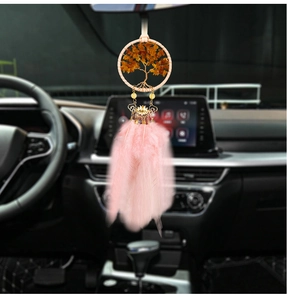 Detail of tree of life car charm with pink feathers and amber stones on rearview mirror