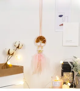 Detail of pink feather dreamcatcher with citrine tree of life in a cozy home setting