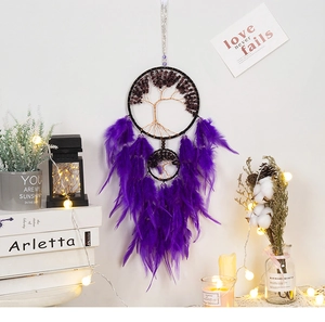Detail of amethyst tree of life dreamcatcher with purple feathers and warm LED lighting