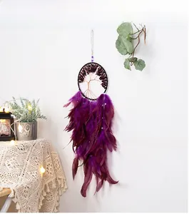 Detail of bohemian tree of life dreamcatcher with purple feathers and pearl accents