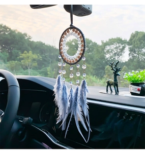 Detalle del atrapasueños bohemio para coche con plumas azules y cuentas en el espejo