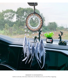 Detalle del atrapasueños para coche con plumas azules y cuentas brillantes en el interior