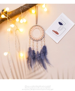 Detalle de atrapasueños bohemio con plumas azules y luces LED cálidas suaves