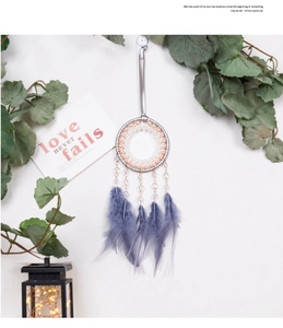 Detalle de atrapasueños con aro plateado, perlas rosas y plumas púrpuras suaves