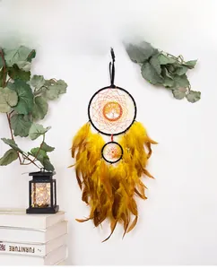 Handmade Tree of Life dream catcher hanging on wall with yellow feathers and beads