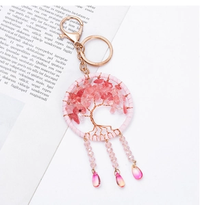 Detail of pink crystal Tree of Life keychain with golden wire and teardrop pendants