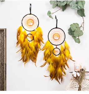 Detail of life tree crystal pendant and yellow feathers with warm LED string lights