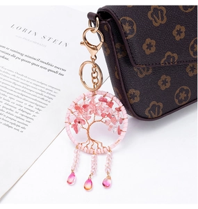 Macro detail of a pink Tree of Life keychain with crystal stones and teardrop charms