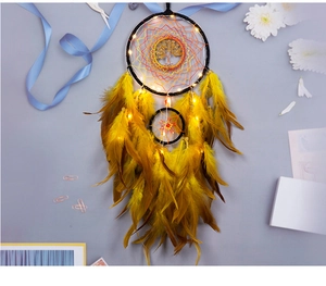 Detail of dream catcher with yellow feathers and tree of life metal pendant and LED lights