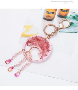 Macro detail of Tree of Life keychain with pink crystals and teardrop pendant charm