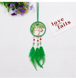 Detail of Tree of Life dreamcatcher with green feathers and Santa Claus ornament