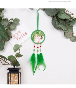 Detail of Christmas tree of life dreamcatcher with green feathers and Santa charm