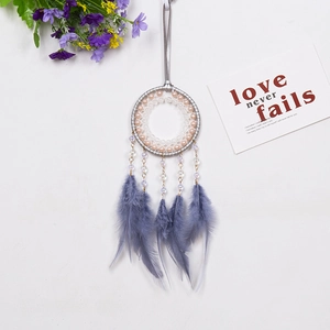 Atrapasueños bohemio con plumas azul oscuro y cuentas sobre fondo blanco limpio
