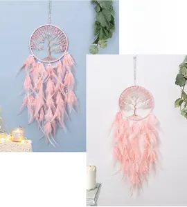 Close-up of pink dreamcatcher with tree of life design, feathers and pearls hanging