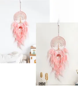 Detailed view of pink feather Tree of Life dreamcatcher with crystal beads on wall